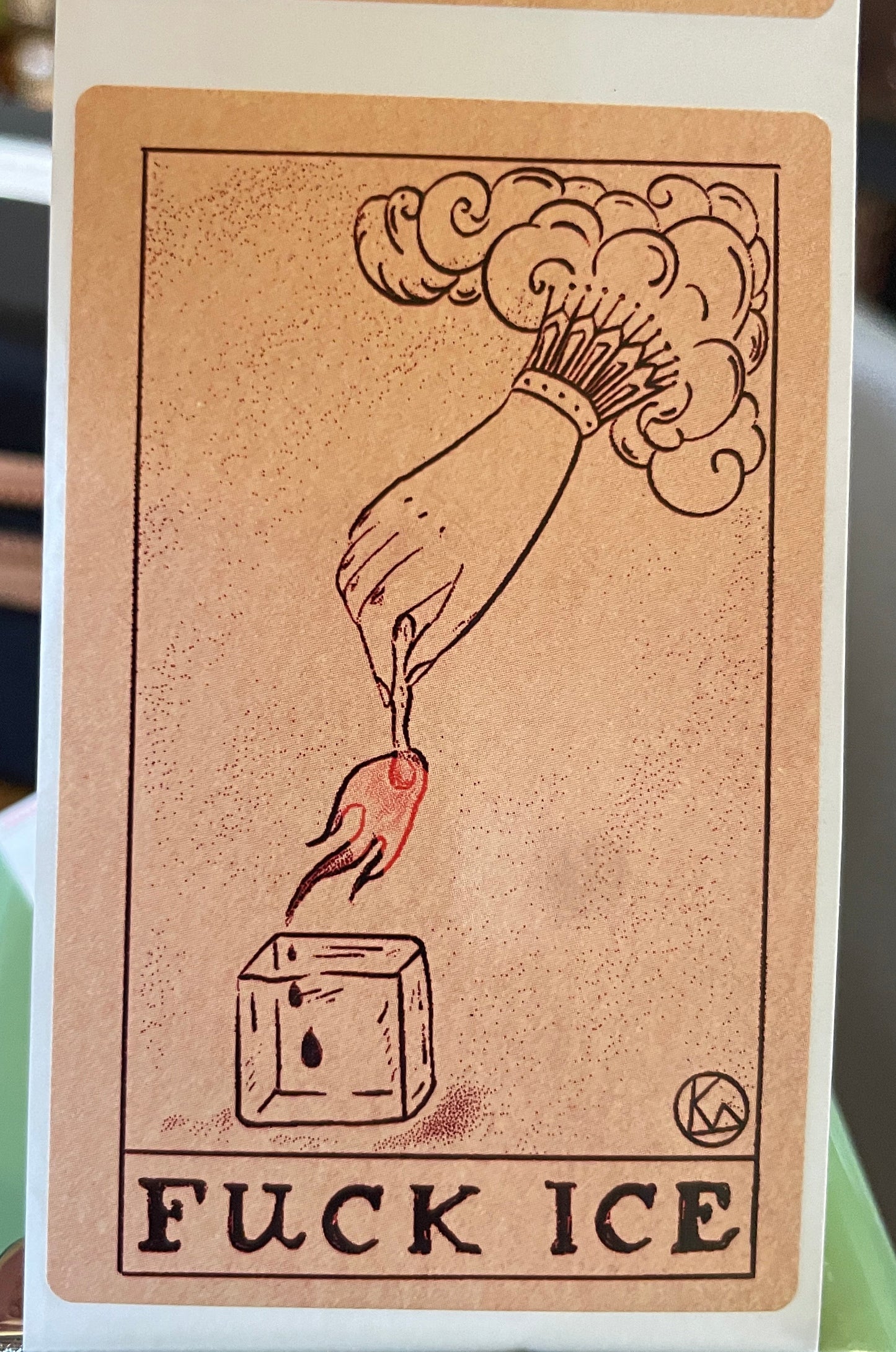 Card with a hand holding a flame and a block of ice, surrounded by 'FUCK ICE' text.