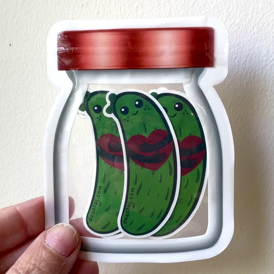 Plastic bag that looks like a jar filled with stickers that look like adorable happy pickles holding a heart.